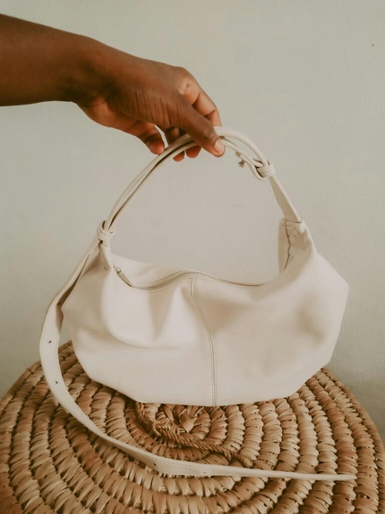 pexels-photo-11648353-11648353 Elegant white handbag held by hand, showcasing minimalist design and fashion.